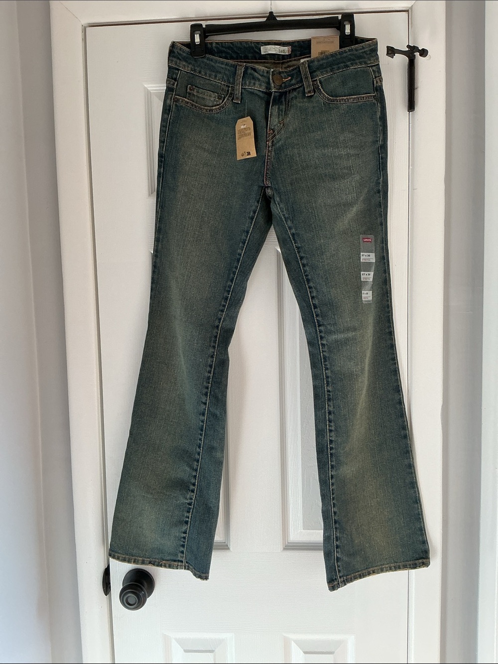 Levi's 545 jeans, featuring a low-rise fit and medium-wash distressed blue denim
